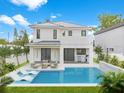 A stunning backyard with a modern pool, lounge chairs, and outdoor dining with built in barbeque at 2483 Bay St, Sarasota, FL 34237