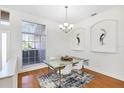 Bright dining room with modern decor, a glass table, and hardwood floors at 2931 Bravura Lake Dr, Sarasota, FL 34240
