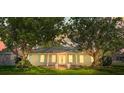 Beautiful home front, framed by mature trees at sunset at 2961 Valencia Rd, Venice, FL 34293