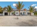 Charming one-story home featuring a white exterior with a blue front door and well-maintained landscaping at 305 73Rd St, Holmes Beach, FL 34217