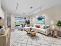 Inviting living room featuring a plush white sofa, modern art, and a seamless transition to the outdoor patio area at 3835 Alamanda Dr, Sarasota, FL 34238