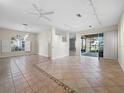 Spacious living room featuring tile flooring, modern lighting fixtures, and sliding glass doors to the lanai at 3835 Alamanda Dr, Sarasota, FL 34238