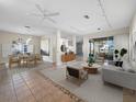 Bright living room with neutral decor, dining area, tile flooring, and seamless access to the outdoor living space at 3835 Alamanda Dr, Sarasota, FL 34238