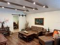 Inviting living room with hardwood floors, wood beam ceiling, comfortable leather seating, and stylish rustic decor at 4408 125Th W St, Cortez, FL 34215