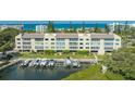 Condo exterior features a boat dock, manicured lawn, and views of the serene waters at 4500 Gulf Of Mexico Dr # Ph4, Longboat Key, FL 34228