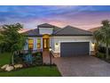 Charming home featuring a landscaped front yard, a brick driveway, and a two-car garage at 4726 Zeno Ct, Bradenton, FL 34211