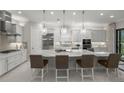 Elegant kitchen featuring a large island with seating, pendant lighting, and modern stainless steel appliances at 4726 Zeno Ct, Bradenton, FL 34211