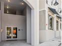 Exterior shot of the building entrance showing concrete sidewalks and walls with double glass doors at 516 Tamiami S Trl # 102, Nokomis, FL 34275