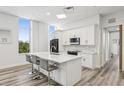 Modern kitchen featuring white cabinetry, stainless steel appliances, a marble countertop island, and bar stool seating at 516 Tamiami S Trl # 102, Nokomis, FL 34275