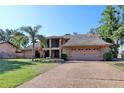 Inviting two-story home featuring a well-maintained lawn, mature landscaping, and ample parking space at 5340 Dominica Cir, Sarasota, FL 34233