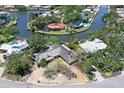 Aerial view of a waterfront home with lush greenery and canal access at 5502 Shadow Lawn Dr, Sarasota, FL 34242