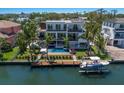 Waterfront home showcasing a private pool, boat dock, and outdoor lounge areas, nestled in a serene neighborhood at 581 Kingfisher Ln, Longboat Key, FL 34228