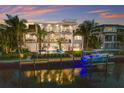 Stunning waterfront home with multi-level balconies, a private pool, dock, and boat lift surrounded by lush tropical landscaping at 581 Kingfisher Ln, Longboat Key, FL 34228
