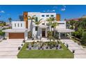 Modern home with a manicured lawn and desert garden, featuring clean lines and a spacious driveway at 581 Kingfisher Ln, Longboat Key, FL 34228