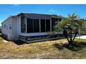 Home with a screened in lanai and low maintenance landscaping with tropical trees in a sunny neighborhood at 606 Cyprus Ct, Bradenton, FL 34207