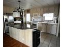 Functional kitchen with tile floor and a U-shaped island with granite countertop at 606 Cyprus Ct, Bradenton, FL 34207