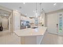 Bright kitchen features a large island, pendant lighting, stainless steel appliances, and white cabinetry at 6120 Plateau Ct, Bradenton, FL 34203