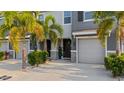 Inviting townhome entrance featuring a stylish door, manicured plants, and pristine driveway at 6516 Serenity Fall Ln, Sarasota, FL 34240