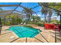 Inviting screened-in pool with spa, patio seating, and lush tropical surroundings for ultimate outdoor living at 7209 35Th E St, Sarasota, FL 34243