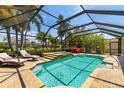 Sparkling screened-in pool with sun loungers, spa, and lush tropical landscaping perfect for relaxation at 7209 35Th E St, Sarasota, FL 34243