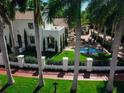 Aerial shot showcasing the home, pool, and spacious backyard surrounded by lush landscaping and palm trees at 76 S Washington Dr, Sarasota, FL 34236