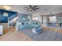 Bright, open-plan living room with hardwood floors, stairs, a ceiling fan, and open to the dining area at 803 Gladiolus St, Anna Maria, FL 34216