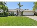 Charming single-story home featuring a well-manicured lawn, mature palms, and a two car garage at 8146 Shadow Pine Way, Sarasota, FL 34238