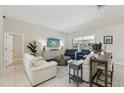 Bright living room with tile floors, modern furniture, and sliding glass doors to the pool at 8146 Shadow Pine Way, Sarasota, FL 34238