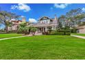 Well-maintained two-story home with lush green lawn, mature trees, and an inviting front porch at 829 Bayshore Blvd, Tampa, FL 33606