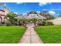 Charming two-story home with a manicured lawn, walkway, and inviting front porch lined with tropical palm trees at 829 Bayshore Blvd, Tampa, FL 33606
