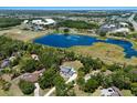 Breathtaking aerial view of a home with a pool next to a picturesque lake at 10712 Forest Run Dr, Bradenton, FL 34211