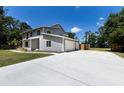 Contemporary two-story home showcasing a spacious driveway leading to an attached two-car garage at 10712 Forest Run Dr, Bradenton, FL 34211