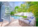 Private backyard oasis with a pool, lounge area, and lush tropical landscaping at 159 Crescent Dr, Anna Maria, FL 34216