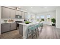 Modern kitchen featuring stainless steel appliances, light gray cabinetry, and a large center island with seating at 160 Eagleston Ln, Lakewood Ranch, FL 34240