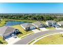 A picturesque view showing several well-maintained single-story homes and a tranquil pond surrounded by lush greenery at 17555 Cantarina Cv, Bradenton, FL 34211