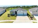 Charming single-story home featuring stone accents, a three-car garage, and lush landscaping in the front yard at 17555 Cantarina Cv, Bradenton, FL 34211