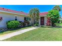 Charming home featuring a beautiful red tile roof, lush tropical landscaping, and a well-maintained lawn at 2121 Pueblo Cir # V6, Sarasota, FL 34231