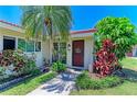 Beautiful condo featuring lush tropical landscaping, healthy green grass, and a welcoming front entrance at 2121 Pueblo Cir # V6, Sarasota, FL 34231