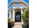 Elegant front entrance showcasing stately columns, a decorative transom window, and beautifully manicured landscaping at 2980 Seasons Blvd, Sarasota, FL 34240