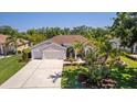 Well-manicured lawn and landscaping complement this single-story home with a two-car garage at 3816 Little Country Rd, Parrish, FL 34219