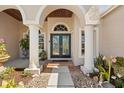 Arched front entrance featuring a stylish double door and elegant columns at 3816 Little Country Rd, Parrish, FL 34219