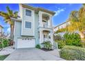 Charming two-story coastal home with a light blue exterior, lush landscaping, and a two-car garage at 426 Magnolia Ave, Anna Maria, FL 34216