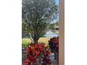View of pond and fountain, with green, brown grass and decorative plants on a sunny day at 4721 Turnberry Cir, North Port, FL 34288
