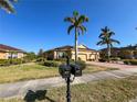 Well-maintained single-story house with palm trees and lush lawn, with brick paver driveway on a sunny day at 4721 Turnberry Cir, North Port, FL 34288