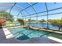 Sparkling pool overlooking a tranquil lake with a screened-in enclosure at 4918 Avon Ln, Sarasota, FL 34238