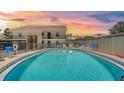 Community pool surrounded by lounge chairs and well maintained landscaping at 525 Barcelona Ave # 207, Venice, FL 34285
