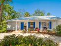 Charming home with a brick-paved driveway, beautiful landscaping, and bright blue shutters at 5432 Cape Leyte Dr, Sarasota, FL 34242