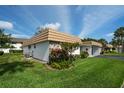 Well-kept home with manicured lawn and stone accents next to a covered carport at 5521 Riverbluff Cir # V-10, Sarasota, FL 34231