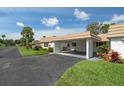 Inviting single-story home showcasing a convenient covered carport and lush, green lawn at 5521 Riverbluff Cir # V-10, Sarasota, FL 34231
