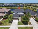 Aerial view of a two-story home with a dark roof, attached garage, and a well-maintained lawn at 5740 Sunflower Cir, Sarasota, FL 34238